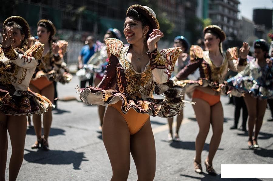 A vibrant street festival in Santiago with performers and a lively crowd