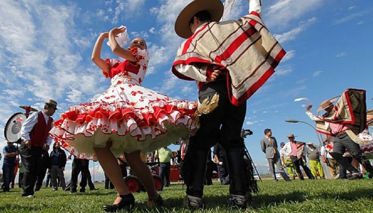 A vibrant scene of a fonda in Parque O’Higgins, with people dancing the cueca and colourful decorations