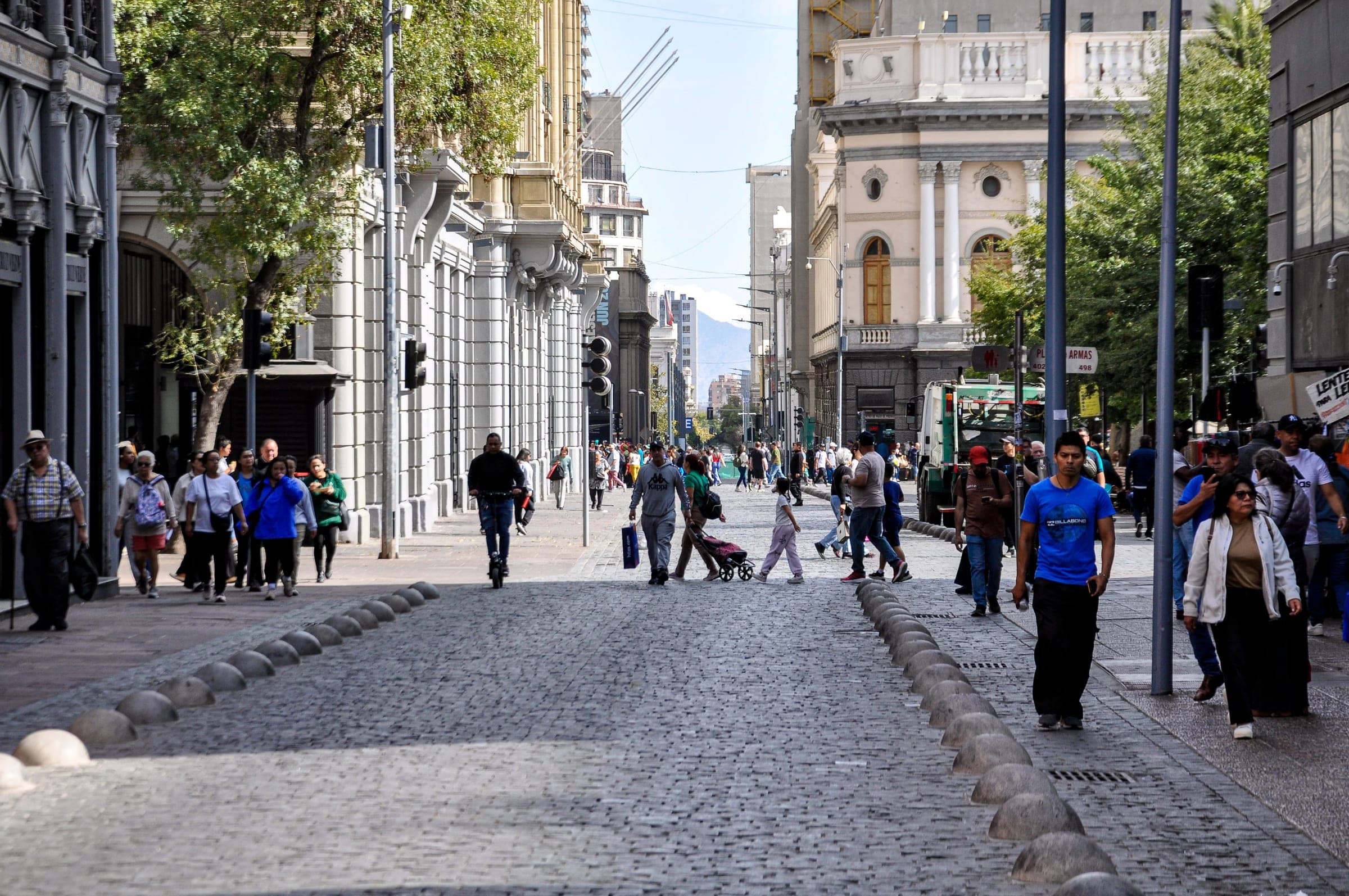 People walking on a busy street in Santiago, Chile, surrounded by historic architecture
