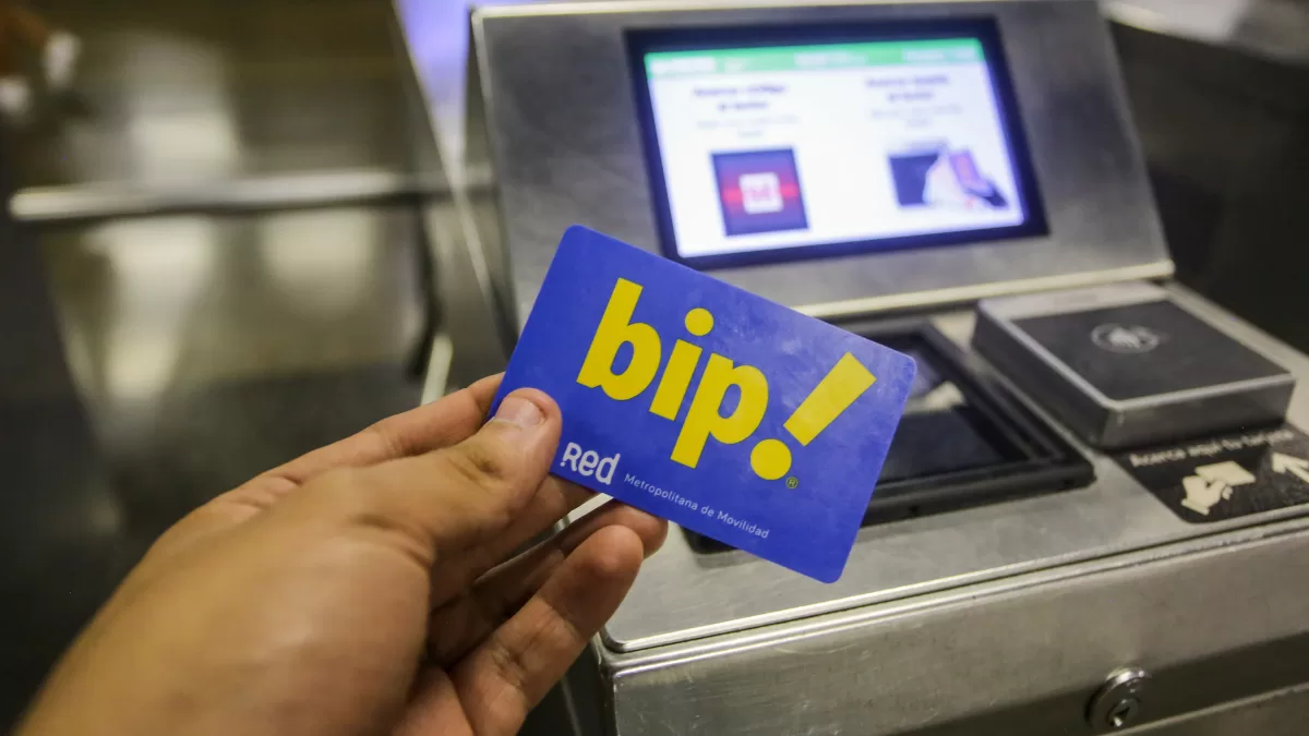 A commuter holding a Bip card at a Santiago Metro turnstile